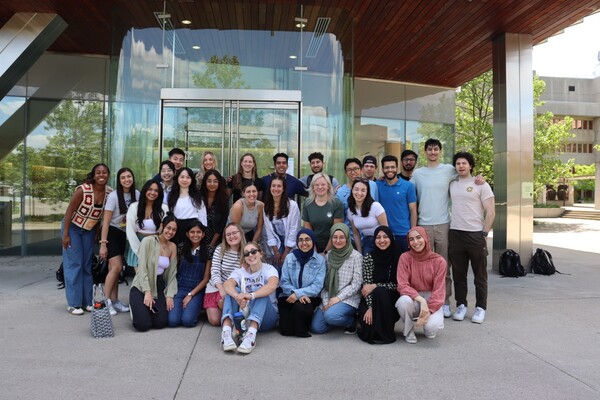 Large group of people posing for a photo in front of a building