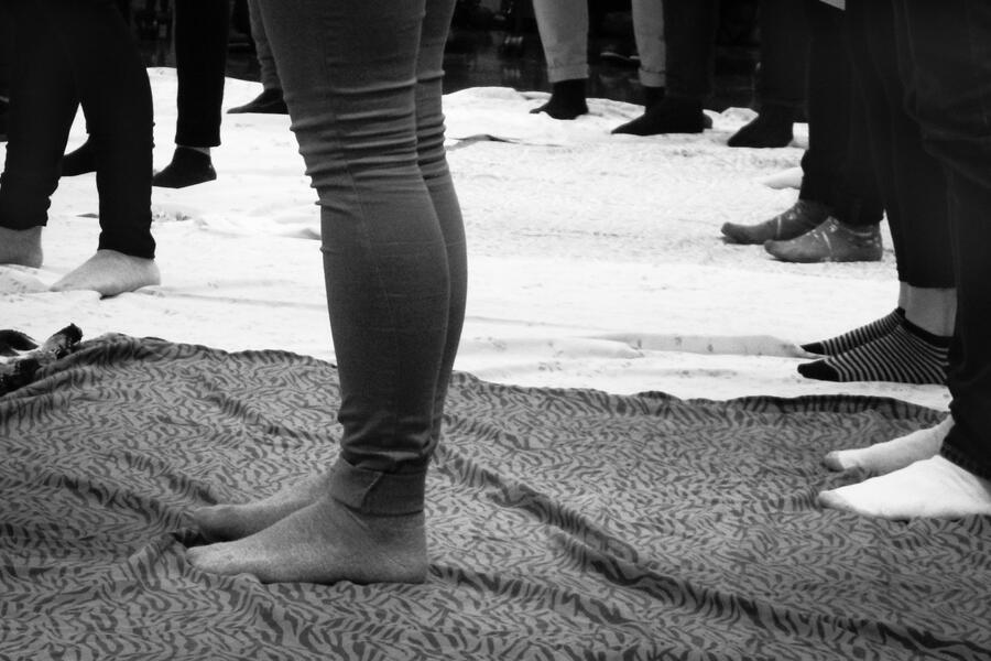 Unidentifiable students stand on blankets as part of the blanket exercise.