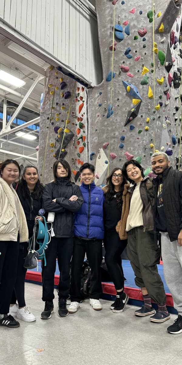 A group of people posing for a photo at rock climbing gym
