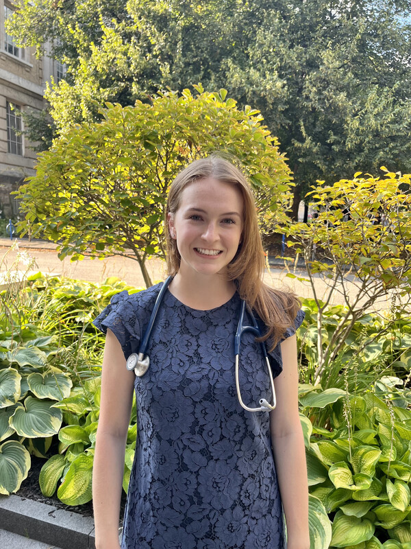 A person smiling with a stethoscope around her neck
